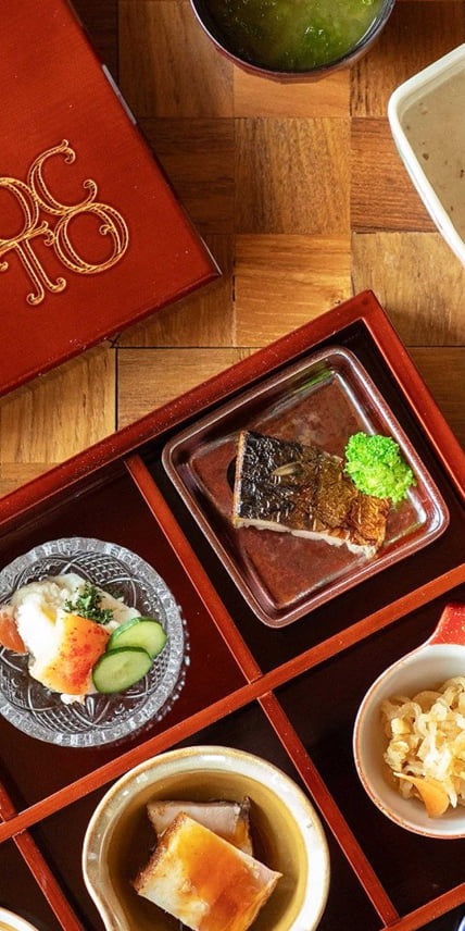 木製の膳に盛り付けられた和食の朝食。焼き魚を中心に、小鉢や汁物が美しく並ぶ。